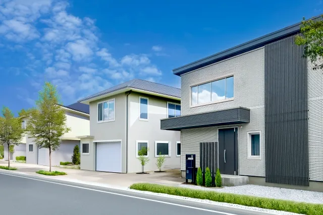 青空の下に並ぶ戸建て住宅。外壁塗装の塗り替え時期を見極める住まいの外観