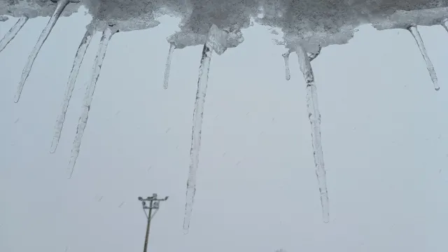雪国の屋根の軒先にできたつらら。積雪による屋根や雨樋の被害のイメージ